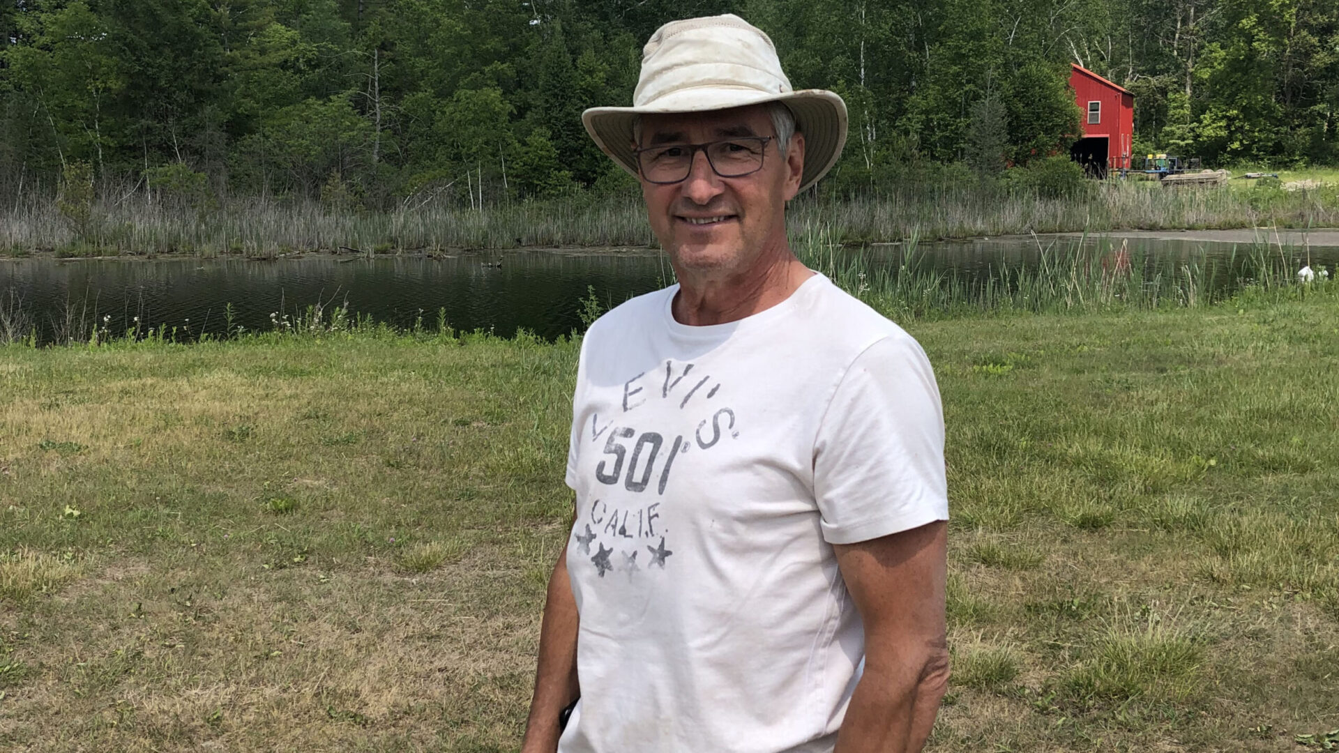 Carl Atkinson on his farm with a wetland in the background.