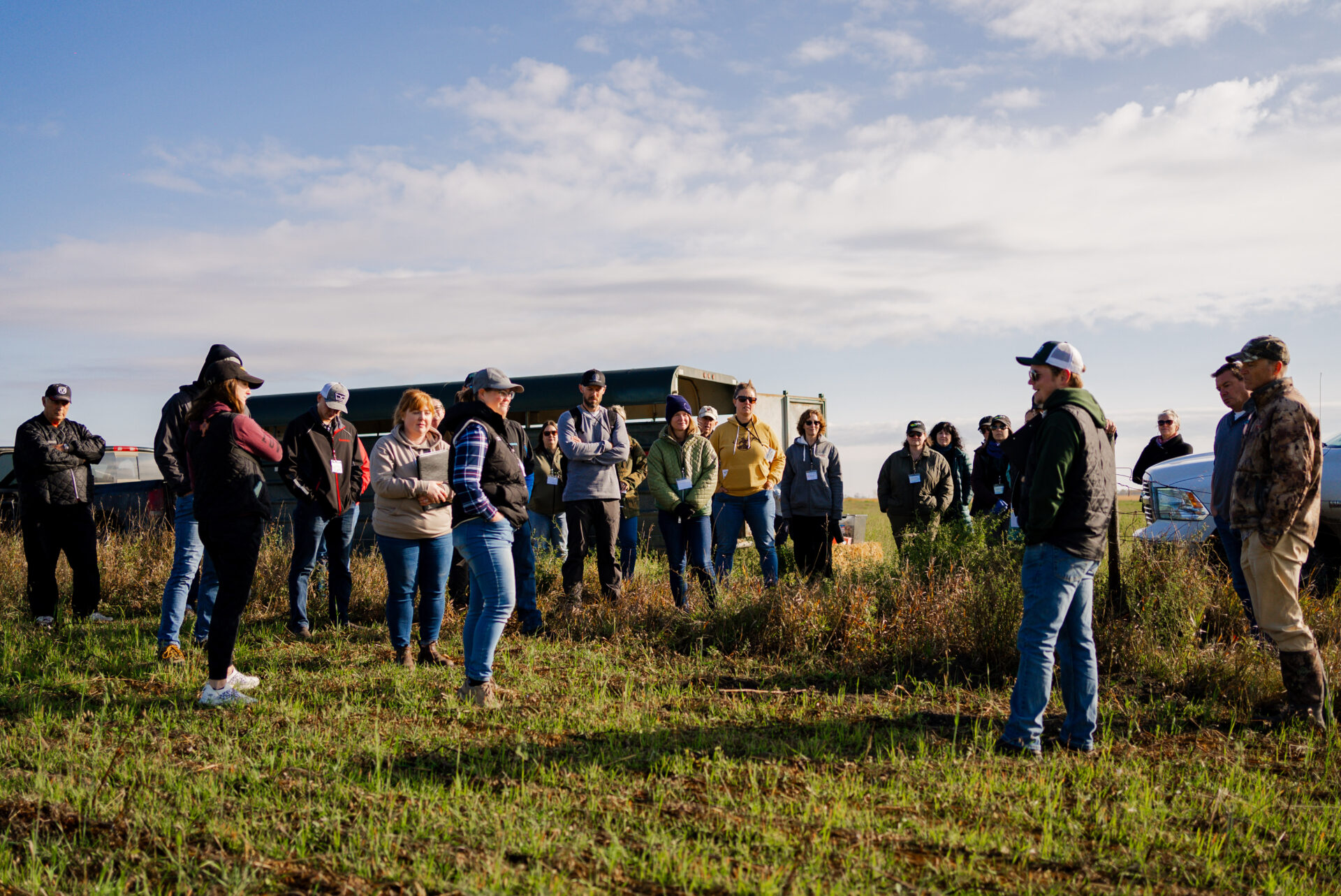 This photo shows Zack Koscielny from Green Beach Farm and Food explaining his Growing Roots project site, which in early summer was a full season cover crop that was roller crimped, which then was seeded as an intercrop of winter wheat and hairy vetch using a no-till drill into crimped cover crop residue.