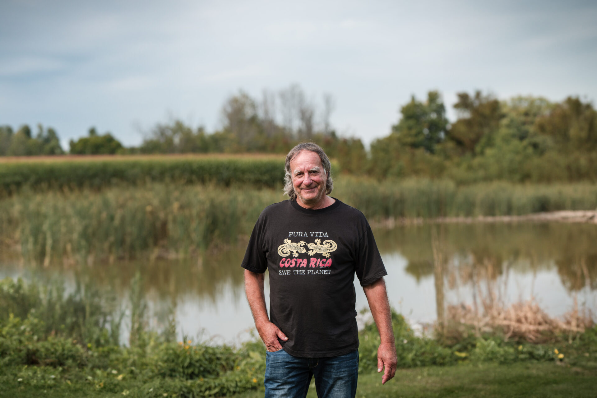 Carl Atkinson on his farm with a wetland in the background.