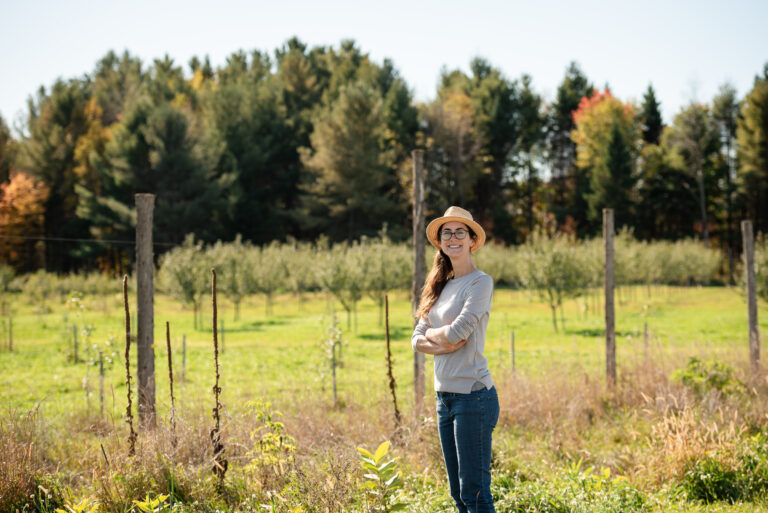 Danielle Newman standing next to her windbreak at Alluvia Farm in Bristol, Quebec.